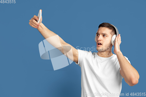 Image of Caucasian young man\'s portrait on blue studio background