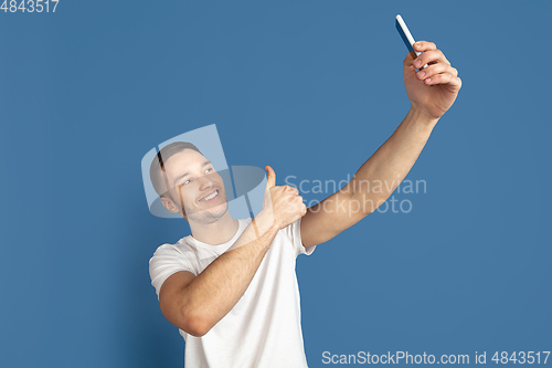 Image of Caucasian young man\'s portrait on blue studio background