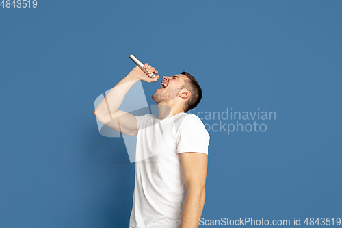 Image of Caucasian young man\'s portrait on blue studio background