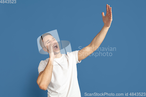 Image of Caucasian young man\'s portrait on blue studio background