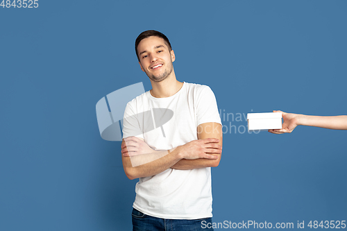 Image of Caucasian young man\'s portrait on blue studio background