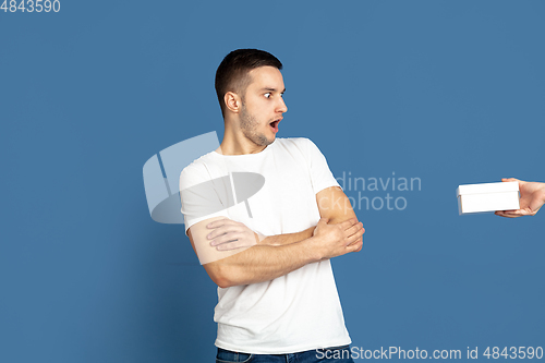 Image of Caucasian young man\'s portrait on blue studio background