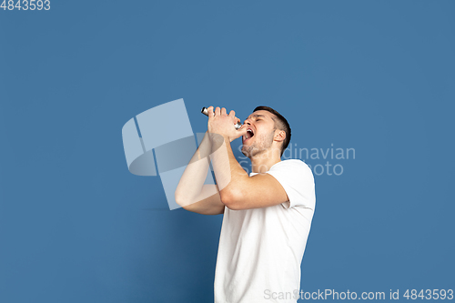 Image of Caucasian young man\'s portrait on blue studio background