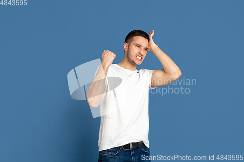 Image of Caucasian young man\'s portrait on blue studio background