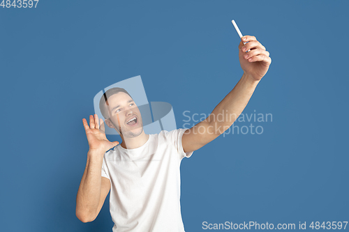 Image of Caucasian young man\'s portrait on blue studio background