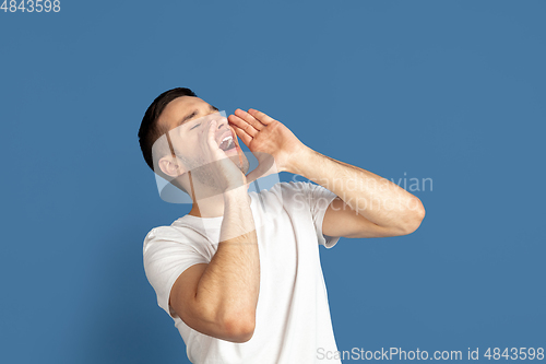 Image of Caucasian young man\'s portrait on blue studio background