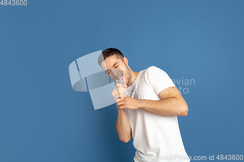 Image of Caucasian young man\'s portrait on blue studio background