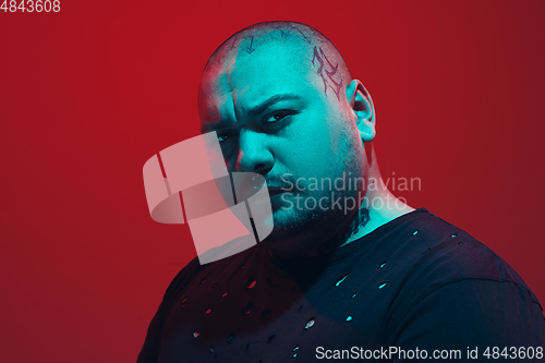 Image of Portrait of a guy with colorful neon light on red background - cyberpunk concept