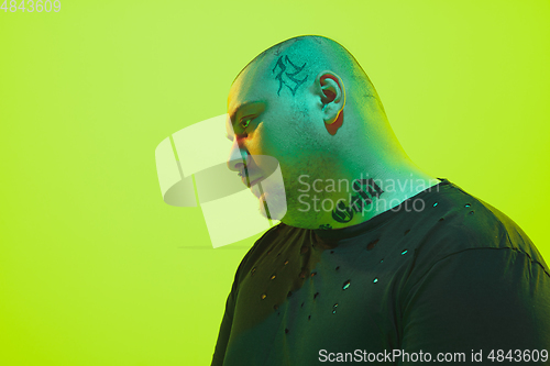 Image of Portrait of a guy with colorful neon light on green background