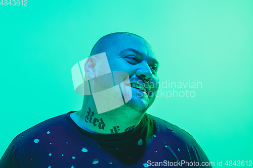 Image of Portrait of a guy with colorful neon light on green background