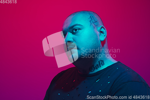 Image of Portrait of a guy with colorful neon light on red background - cyberpunk concept