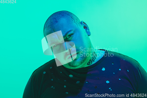 Image of Portrait of a guy with colorful neon light on green background