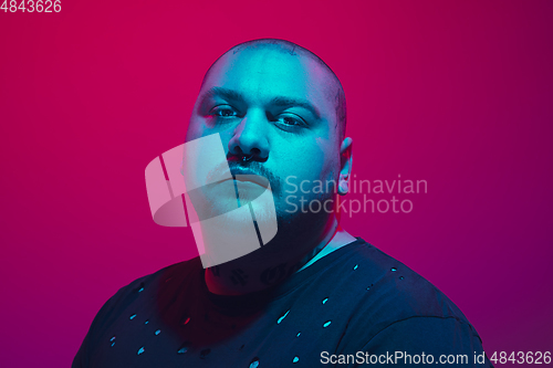 Image of Portrait of a guy with colorful neon light on red background - cyberpunk concept
