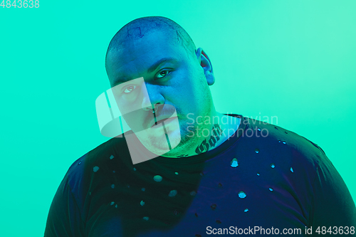 Image of Portrait of a guy with colorful neon light on green background