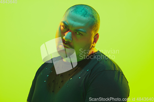 Image of Portrait of a guy with colorful neon light on green background