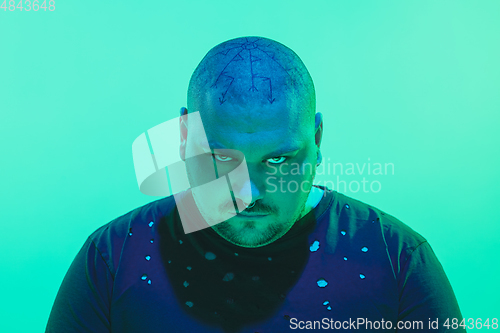 Image of Portrait of a guy with colorful neon light on green background