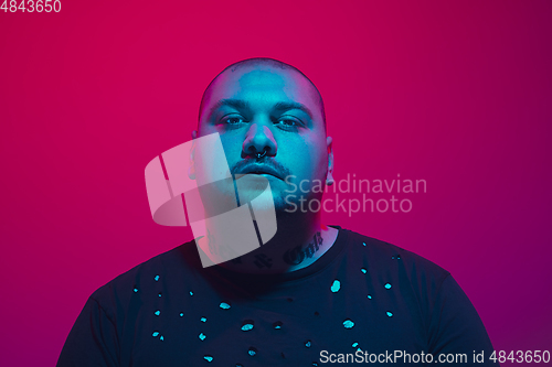 Image of Portrait of a guy with colorful neon light on red background - cyberpunk concept