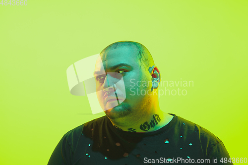 Image of Portrait of a guy with colorful neon light on green background