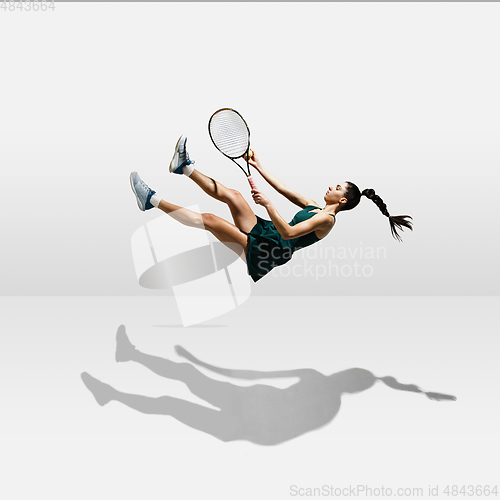 Image of Young caucasian professional sportswoman levitating, flying while playing tennis isolated on white background