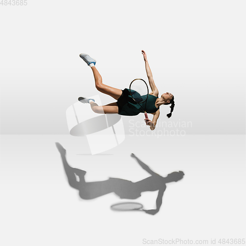 Image of Young caucasian professional sportswoman levitating, flying while playing tennis isolated on white background
