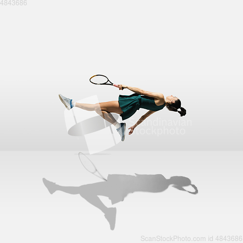 Image of Young caucasian professional sportswoman levitating, flying while playing tennis isolated on white background
