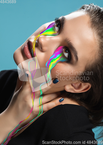 Image of Portrait of young beautiful woman with neon, fluid tears from eyes. Concept of fashion and beauty, emotions and feelings, modern design