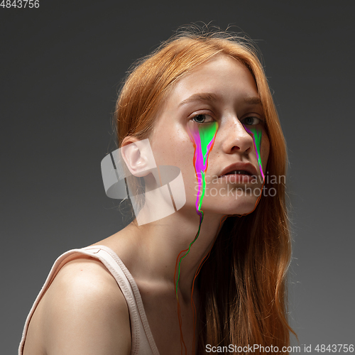 Image of Portrait of young beautiful woman with neon, fluid tears from eyes. Concept of fashion and beauty, emotions and feelings, modern design