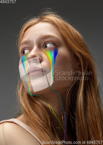 Image of Portrait of young beautiful woman with neon, fluid tears from eyes. Concept of fashion and beauty, emotions and feelings, modern design