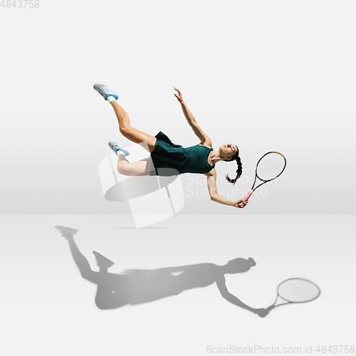 Image of Young caucasian professional sportswoman levitating, flying while playing tennis isolated on white background