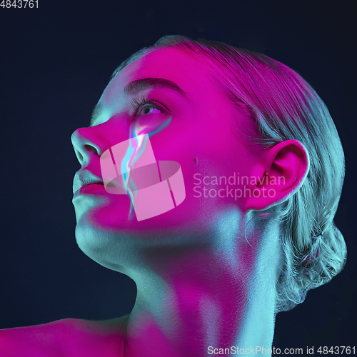 Image of Portrait of young beautiful woman with neon, fluid tears from eyes. Concept of fashion and beauty, emotions and feelings, modern design