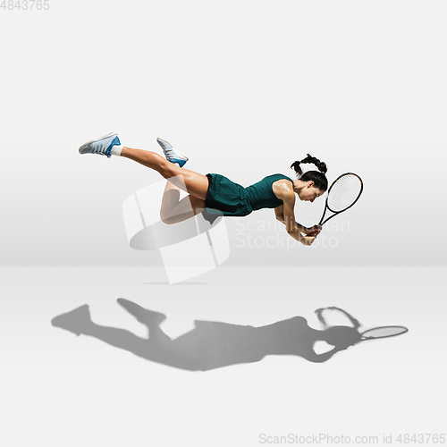 Image of Young caucasian professional sportswoman levitating, flying while playing tennis isolated on white background