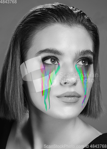 Image of Portrait of young beautiful woman with neon, fluid tears from eyes. Concept of fashion and beauty, emotions and feelings, modern design