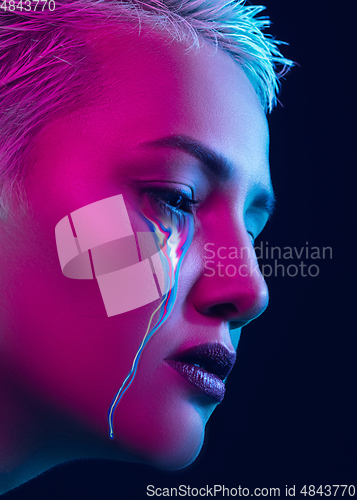 Image of Portrait of young beautiful woman with neon, fluid tears from eyes. Concept of fashion and beauty, emotions and feelings, modern design