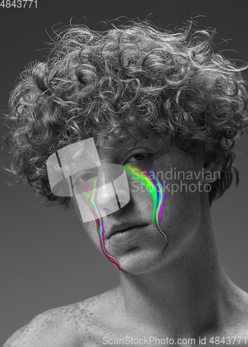 Image of Portrait of young beautiful man with neon, fluid tears from eyes. Concept of fashion and beauty, emotions and feelings, modern design