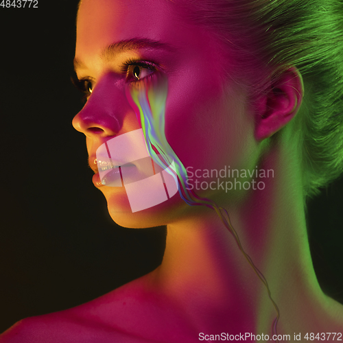 Image of Portrait of young beautiful woman with neon, fluid tears from eyes. Concept of fashion and beauty, emotions and feelings, modern design