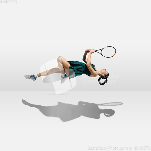 Image of Young caucasian professional sportswoman levitating, flying while playing tennis isolated on white background