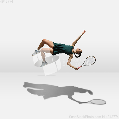 Image of Young caucasian professional sportswoman levitating, flying while playing tennis isolated on white background