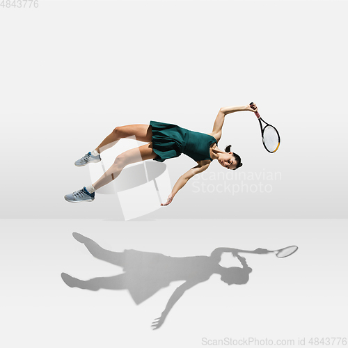 Image of Young caucasian professional sportswoman levitating, flying while playing tennis isolated on white background