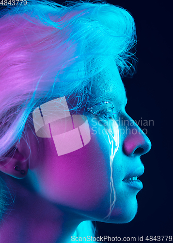 Image of Portrait of young beautiful woman with neon, fluid tears from eyes. Concept of fashion and beauty, emotions and feelings, modern design