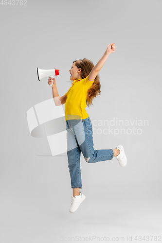 Image of Happy kid, girl isolated on white studio background. Looks happy, cheerful, sincere. Copyspace. Childhood, education, emotions concept