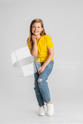 Image of Happy kid, girl isolated on white studio background. Looks happy, cheerful, sincere. Copyspace. Childhood, education, emotions concept