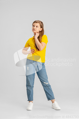 Image of Happy kid, girl isolated on white studio background. Looks happy, cheerful, sincere. Copyspace. Childhood, education, emotions concept