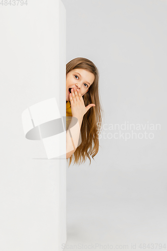 Image of Happy kid, girl isolated on white studio background. Looks happy, cheerful, sincere. Copyspace. Childhood, education, emotions concept