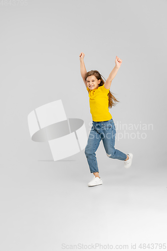 Image of Happy kid, girl isolated on white studio background. Looks happy, cheerful, sincere. Copyspace. Childhood, education, emotions concept