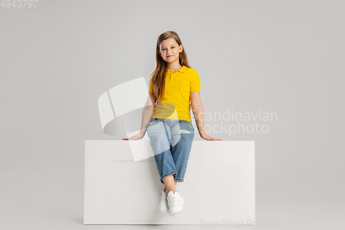 Image of Happy kid, girl isolated on white studio background. Looks happy, cheerful, sincere. Copyspace. Childhood, education, emotions concept