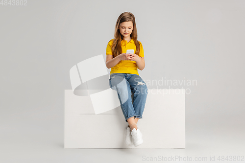 Image of Happy kid, girl isolated on white studio background. Looks happy, cheerful, sincere. Copyspace. Childhood, education, emotions concept