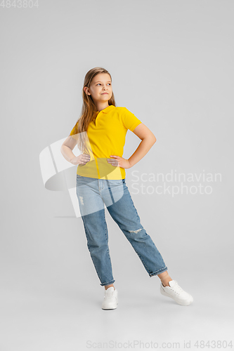 Image of Happy kid, girl isolated on white studio background. Looks happy, cheerful, sincere. Copyspace. Childhood, education, emotions concept