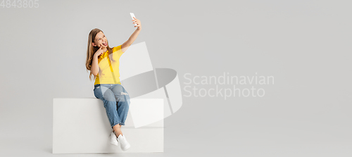 Image of Happy kid, girl isolated on white studio background. Looks happy, cheerful, sincere. Copyspace. Childhood, education, emotions concept