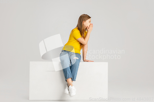 Image of Happy kid, girl isolated on white studio background. Looks happy, cheerful, sincere. Copyspace. Childhood, education, emotions concept