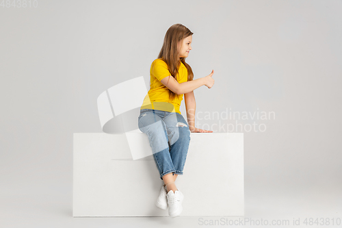 Image of Happy kid, girl isolated on white studio background. Looks happy, cheerful, sincere. Copyspace. Childhood, education, emotions concept